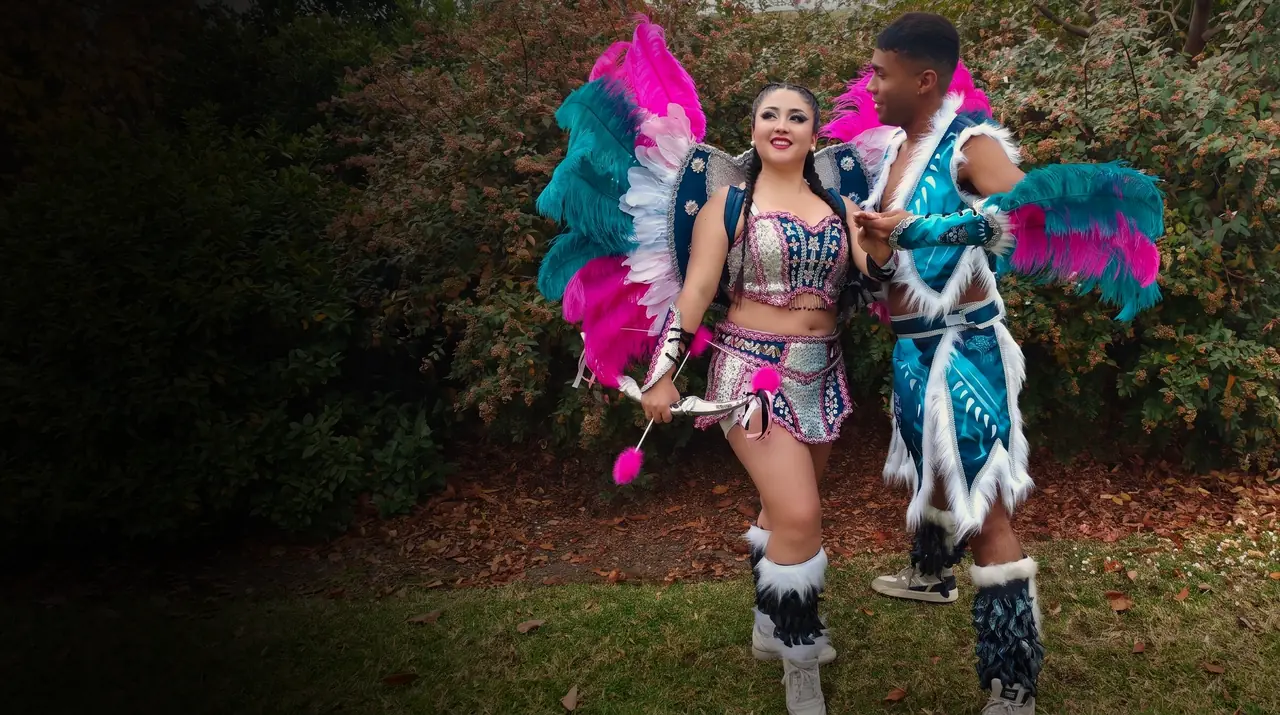 Pareja con el traje de Tobas fucsia y turquesa, lista para el baile